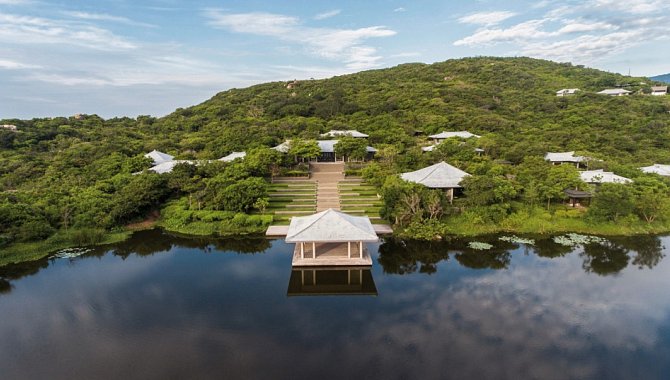 Weitläufige Hotelanlage mit Pavillon am Wasser und Villen im grünen Hügel