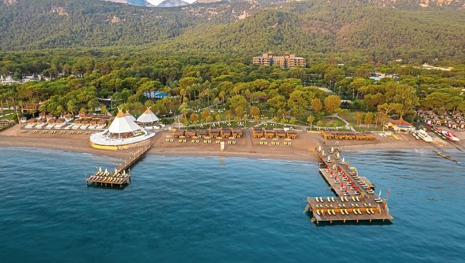 Luftaufnahme des Balmy Foresta Resorts mit zwei Stegen am Strand und grüner Waldkulisse im Hintergrund