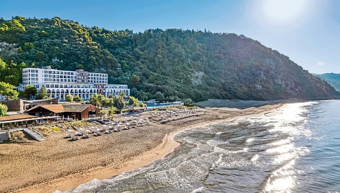 Domes of Corfu Hotel direkt an einem breiten Sandstrand, eingebettet in grüne Hügel und umgeben von Natur