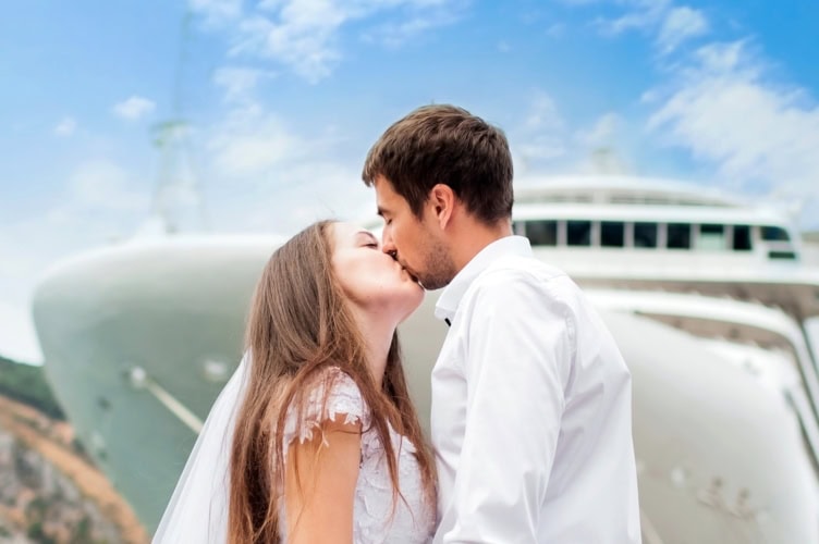 Ehepaar küsst sich auf vor einem Schiff