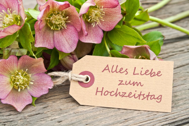 Ein Geschenk mit dekorativem Anhänger und der Aufschrift "Alles Liebe zum Hochzeitstag"