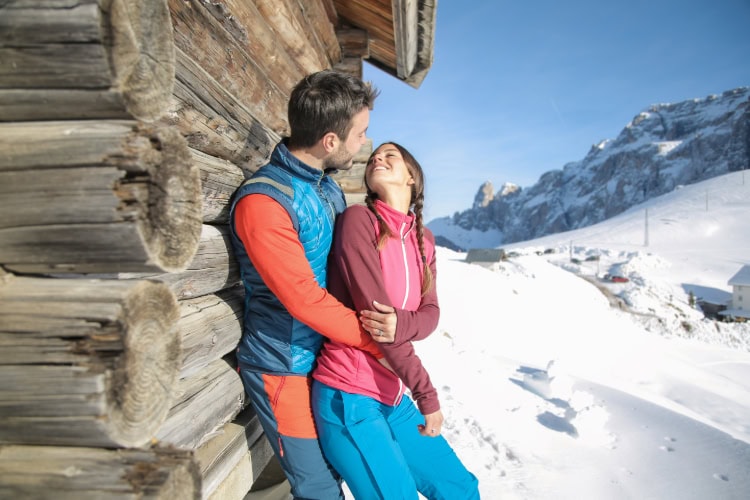 Ein Paar umarmt sich in winterlicher Schneelandschaft.