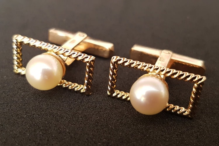 Zwei goldene, rechteckige Manschettenknöpfe mit Perlen