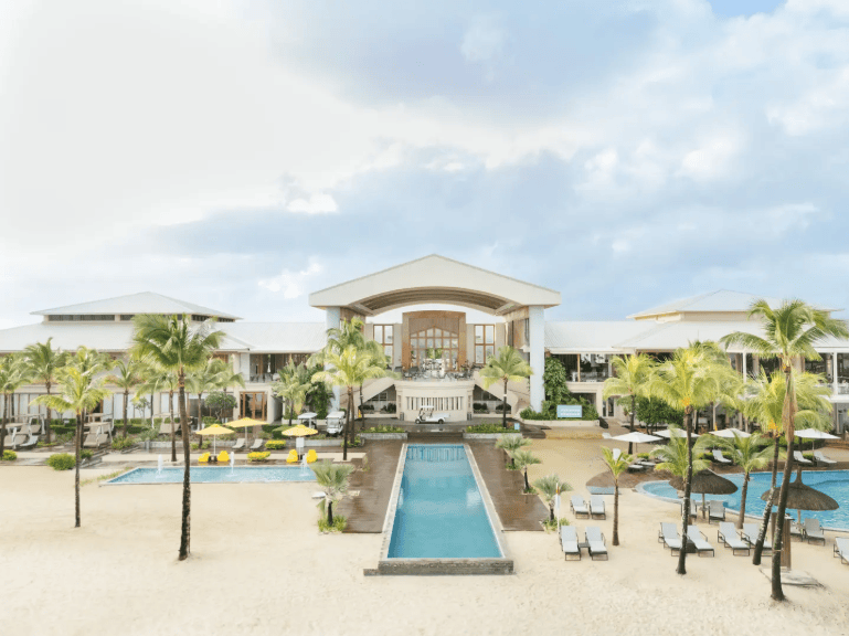 Frontansicht des Resorts mit mehreren Pools, Liegebereichen und Hauptgebäude im Hintergrund