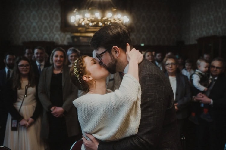 Hochzeitspaar küsst sich beim Hochzeitstanz von allen Gästen