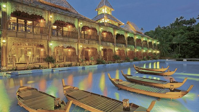 Beleuchtete Hotelfront mit dekorativen Booten