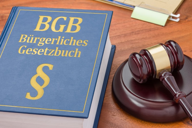 Buch des Bürgerlichen Gesetzbuchs (BGB) mit Paragraphenzeichen auf einem Tisch, daneben ein Richterhammer – Symbolbild für deutsches Zivilrecht.