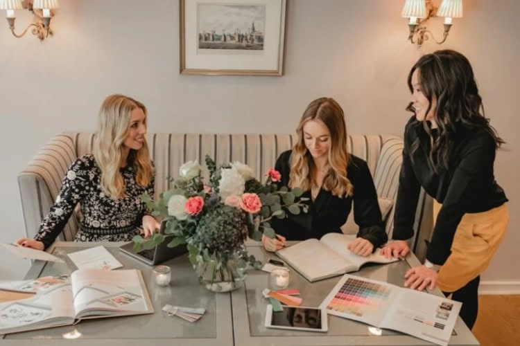Ein Team von Weddingplannern sitzt gemeinsam an einem Tisch